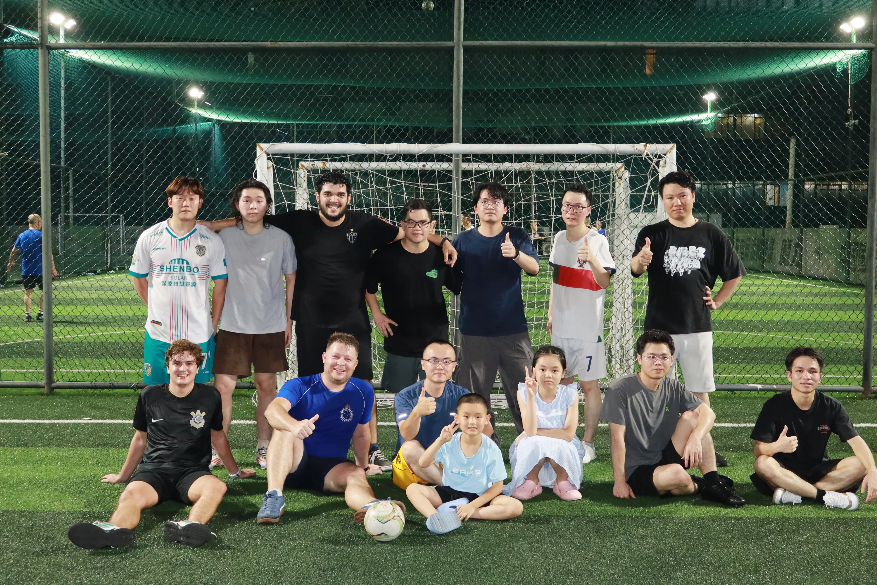 Group photo of multinational engineering team and Brazilian partners after a friendly match.